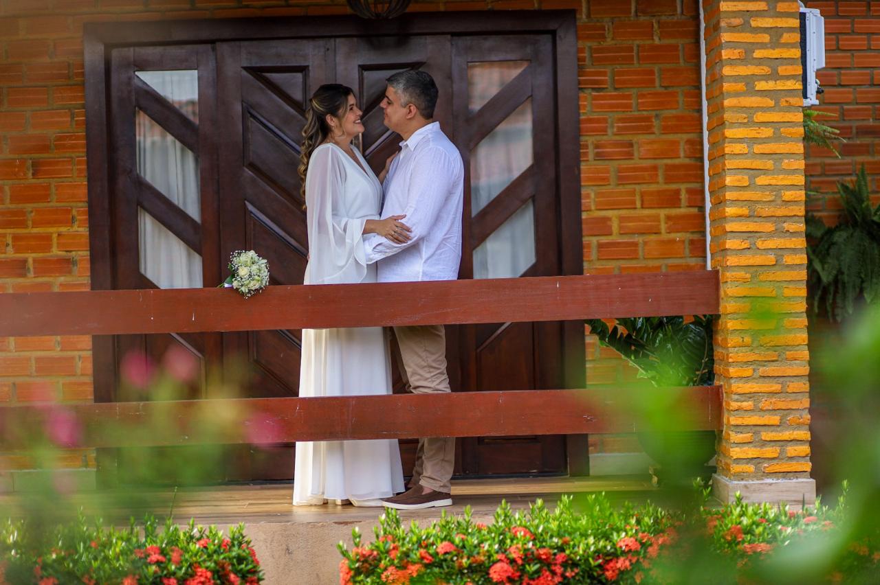 Samara e Francisco juntos diante de uma porta de madeira